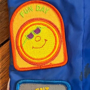 Puede incluir: Una colecci&oacute;n de parches bordados sobre un fondo azul. Los parches presentan varios dise&ntilde;os, incluyendo un oso en la playa, una carita sonriente, un conejo con sombrero de copa y un koala. Los parches tienen texto como "Beach Fun" y "Talent Show".