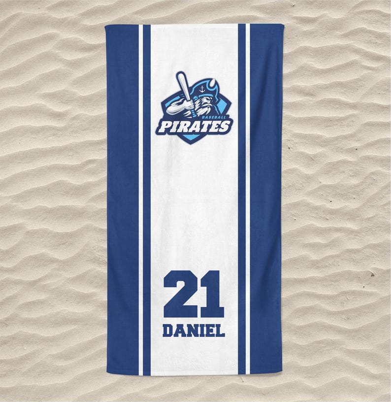 May include: A blue and white beach towel featuring the text "PIRATES" and a baseball bat logo. The towel has a white stripe down the center with the number "21" and the name "DANIEL" printed in black.