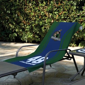 May include: A blue and green baseball-themed beach towel draped over a lounge chair. The towel features the word "Baseball" and the number "48" with the name "Jackson". The towel has a baseball player logo.
