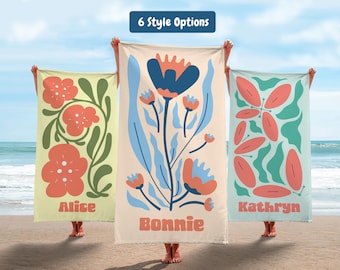 May include: Three beach towels with floral designs are held up on a beach. The towels have different color schemes and patterns, including flowers and abstract shapes. Each towel has a name printed on it: Alice, Bonnie, and Kathryn. The text "6 Style Options" is at the top.