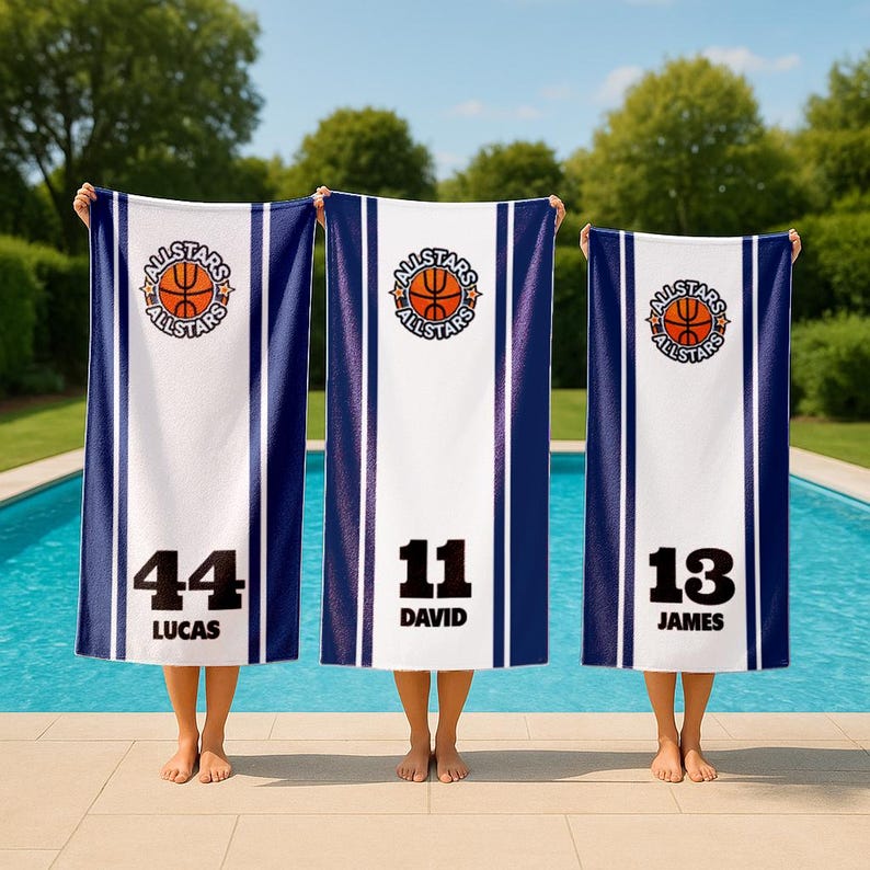 May include: Three personalized basketball-themed beach towels. Each towel features a white center with a basketball logo and the word "ALLSTARS". The towels have blue stripes and include player numbers and names: 44 Lucas, 11 David, and 13 James.