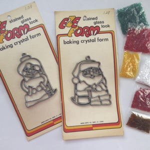 May include: Vintage "Eze Form" baking crystal form kits. The kits include metal outline forms of a woman and Santa Claus, along with small bags of colorful glass crystals. The packaging reads "stained glass look".