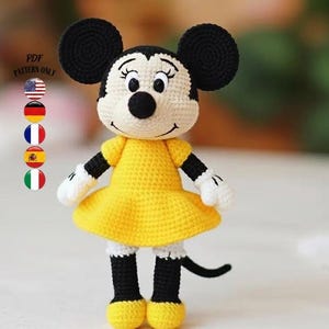 Puede incluir: Muñeca de ganchillo de un personaje de dibujos animados, con un vestido amarillo, zapatos negros y orejas negras. La muñeca tiene guantes blancos y una cola negra. El texto "PDF PATTERN ONLY" es visible en la esquina superior izquierda.