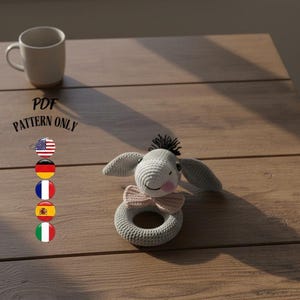 May include: A white ceramic mug with a black handle and the text "But First, Coffee" in a black, handwritten-style font. The mug is on a white surface.