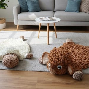 Può includere: Due tappeti a forma di animale in peluche fatti a mano in un soggiorno. Uno è bianco con una testa marrone, l'altro è marrone con una testa marrone chiaro. I tappeti sono su un tappeto grigio, con un divano grigio e un tavolo bianco sullo sfondo.