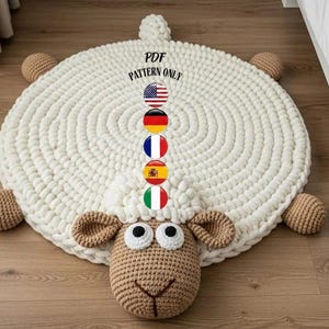 Puede incluir: Una alfombra redonda de ganchillo hecha a mano, de color crema, con forma de oveja. La alfombra tiene una cara de oveja con orejas marrones y un hocico marrón. El texto "PDF PATTERN ONLY" es visible. La alfombra tiene cuatro patas de ganchillo marrones.