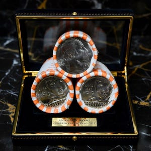 May include: Three rolls of 2022 Anna May Wong quarters in a black display box with gold trim. The top roll shows a George Washington profile, while the bottom two rolls display the Anna May Wong portrait. A gold plaque reads ANNA MAY WONG QUARTER COLLECTION - 2022.