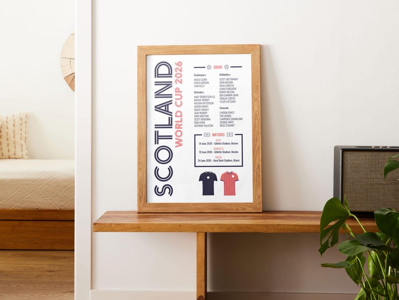 Puede incluir: Una l&aacute;mina enmarcada titulada Scotland World Cup 2026 que muestra una lista de jugadores, fechas y lugares de los partidos. El dise&ntilde;o incluye un esquema de color azul oscuro y rojo con ilustraciones de dos camisetas de f&uacute;tbol en la parte inferior.