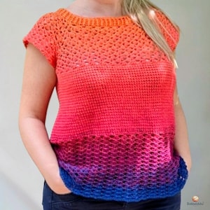 May include: A short-sleeved crochet top featuring a vibrant gradient color transition from orange at the neckline to red, magenta, purple, and blue at the hem. The garment displays a mix of solid and openwork stitch patterns with the Bobbeldidu logo.