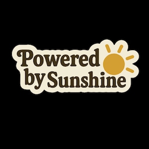 May include: A sticker with the text "Powered by Sunshine" in brown letters on a cream-colored background. A yellow sun graphic is to the right of the text. The sticker has a white border and is set against a black background.