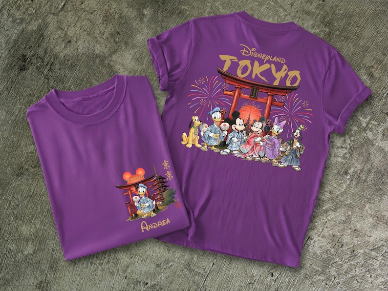 May include: Two purple t-shirts featuring Disney characters in traditional Japanese attire. One shirt has a front graphic of Donald Duck and a Japanese structure, the other has a back graphic with the text "Disneyland Tokyo" and more characters.