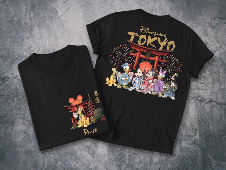 May include: Two black t-shirts featuring Disney characters in traditional Japanese attire. One shirt displays Pluto with a pagoda and the word "Pluto". The other shirt shows Mickey, Minnie, Donald, Daisy, and Goofy with "Disneyland TOKYO" and fireworks.