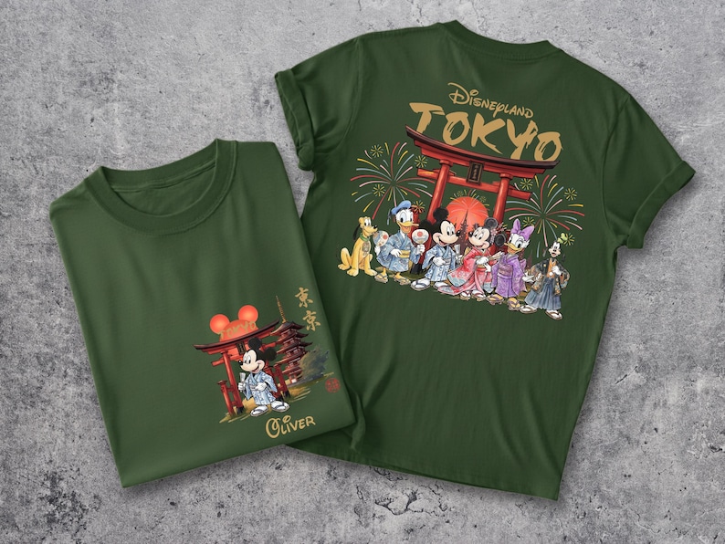 May include: Two dark green t-shirts with Japanese-themed Disney graphics. One shirt features Mickey Mouse in a kimono with a pagoda, the other has a Disneyland Tokyo design with various Disney characters in traditional Japanese attire.