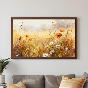 May include: A framed watercolor painting of a field of wildflowers. The artwork features orange poppies and white daisies among tall grasses, with a warm, golden color palette. The painting is displayed in a dark brown wooden frame.