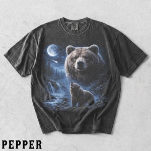 May include: Dark grey t-shirt with a detailed illustration of a bear in a forest under a full moon. The design includes a large bear's face and a smaller bear howling near a waterfall. The word "PEPPER" is printed at the bottom.