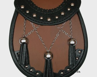Può includere: Un sporran in pelle marrone con patta e finiture in pelle nera. Borchie e catene color argento adornano lo sporran, che presenta tre nappe nere. Accessorio tradizionale scozzese.