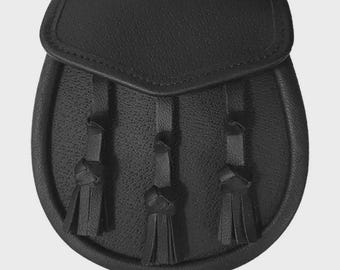 May include: A black leather sporran with a rounded bottom and a flap closure. The sporran features three decorative tassels hanging from the front. The leather has a textured appearance.