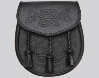 May include: Black leather sporran with Celtic knotwork design. The sporran features a flap closure with embossed knotwork and three decorative tassels. The pouch has a textured surface and a rounded bottom.
