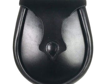 May include: A black leather sporran, a traditional Scottish accessory. The sporran has a rounded bottom and a flap closure. The front features a decorative, stitched design. The leather has a glossy finish.