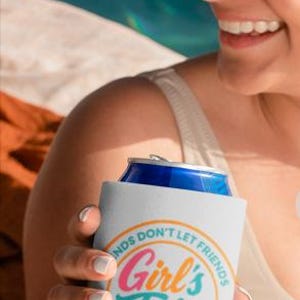 Op de afbeelding: Witte blikjeskoeler met de tekst "Girl's Trip" in een kleurrijk cirkelvormig ontwerp. De tekst "Friends don't let friends do stupid stuff... alone" omringt de hoofdtekst. De koeler bevat een blauw blikje.
