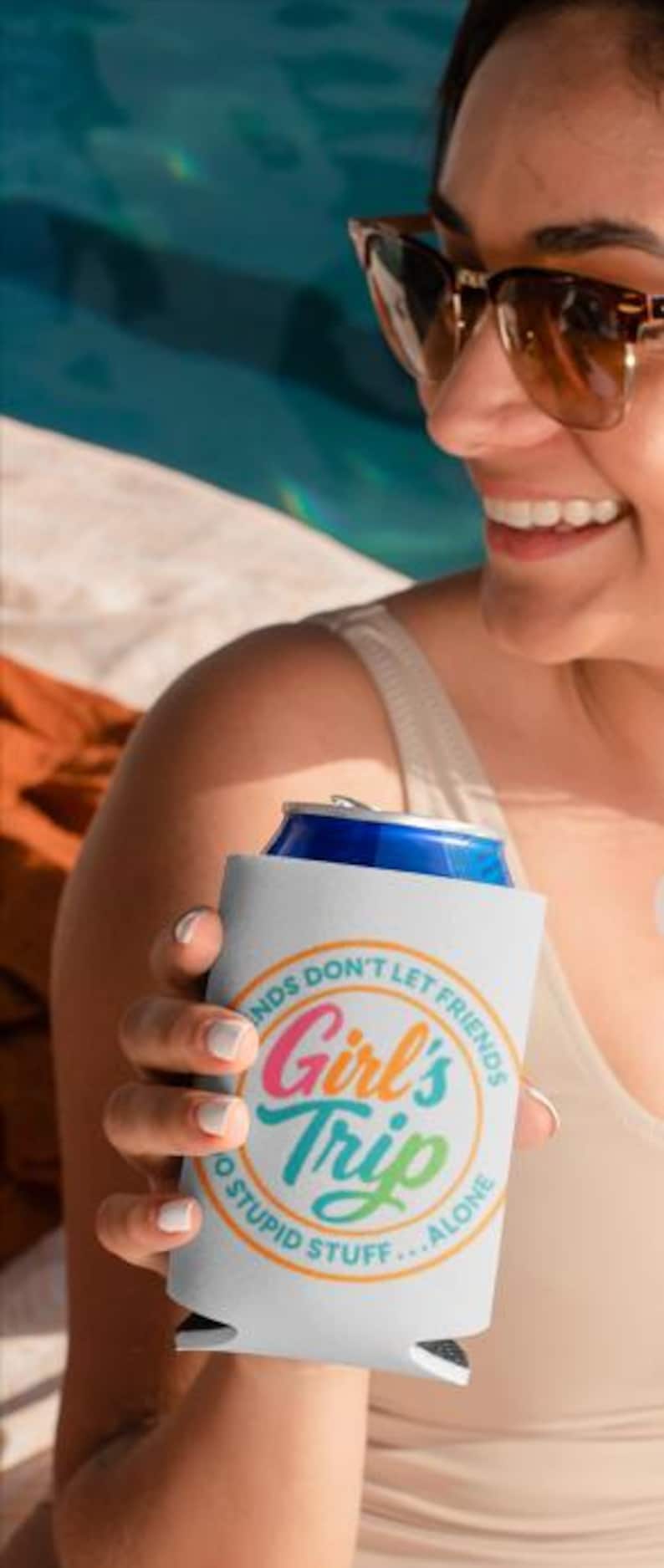 Op de afbeelding: Witte blikjeskoeler met de tekst "Girl's Trip" in een kleurrijk cirkelvormig ontwerp. De tekst "Friends don't let friends do stupid stuff... alone" omringt de hoofdtekst. De koeler bevat een blauw blikje.