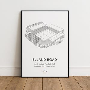 Puede incluir: Impresión enmarcada en negro de Elland Road, sede del Leeds United Football Club. La impresión presenta un dibujo lineal detallado del estadio, con el texto "Elland Road" e información del club. Capacidad: 37.645.