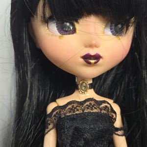 May include: A white ceramic mug with a black handle and the text "But First, Coffee" in a black, handwritten-style font. The mug is on a white surface.