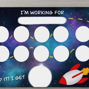 Peut inclure: Un tableau de récompenses sur le thème de l'espace. Le fond est une galaxie bleu foncé et violette avec des étoiles blanches. Il y a un espace vide en haut avec le texte "I'M WORKING FOR" et une fusée.