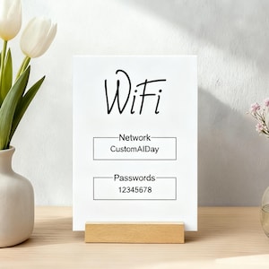 May include: A white rectangular sign with the word "Wifi" in black script. Below, it displays the network name "CustomAIDay" and the password "12345678". The sign is held by a small wooden stand. Decorative flowers are in the background.