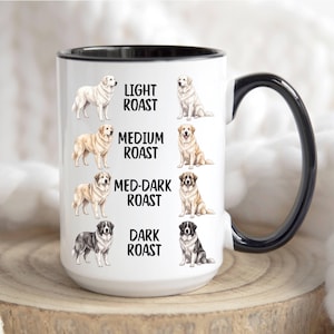 Puede incluir: Una taza de cerámica blanca con interior y asa negros, que presenta ilustraciones de perros en varios tonos junto al texto LIGHT ROAST, MEDIUM ROAST, MED-DARK ROAST y DARK ROAST, representando la progresión de los niveles de tueste.