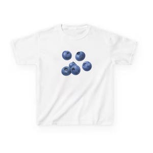 May include: White t-shirt with a design of six blueberries. The blueberries are a vibrant blue colour and appear to be fresh. The t-shirt has a classic crew neck, suitable for everyday wear.