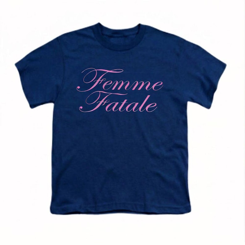 以下が含まれることがあります： 前面にピンク色の筆記体で「Femme Fatale」と書かれたネイビーブルーのTシャツ。テキストは筆記体フォントです。Tシャツは無地で、半袖です。