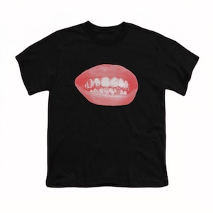 Może przedstawiać: Czarny t-shirt z grafiką ust z czerwonymi ustami i białymi zębami. Projekt jest wyśrodkowany na przodzie koszulki. T-shirt jest wykonany z miękkiego, wygodnego materiału.