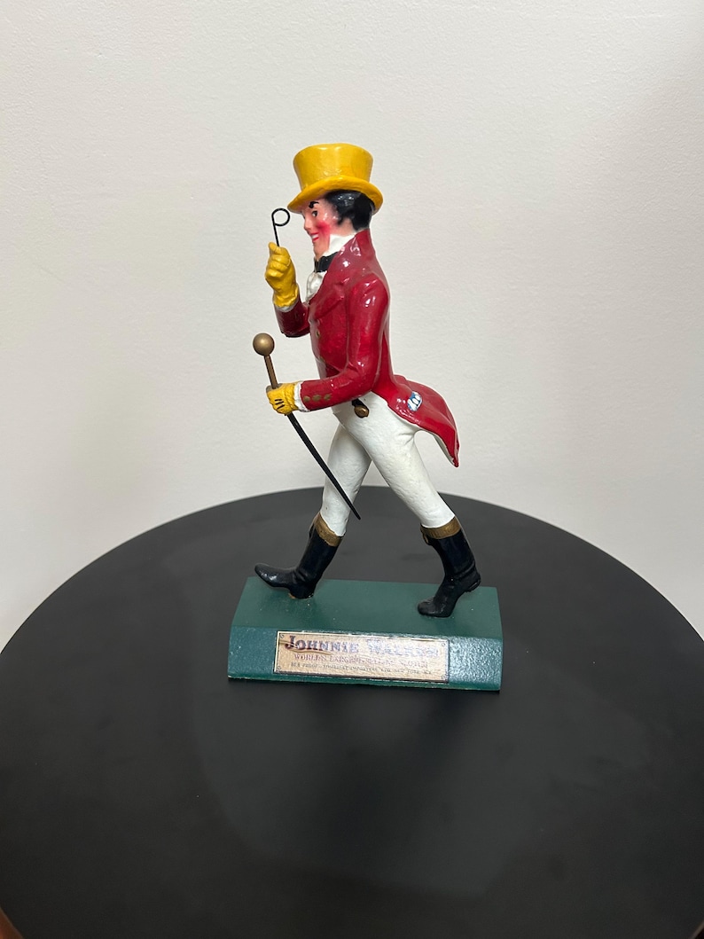 以下が含まれることがあります： 赤いコート、黄色のシルクハット、白いズボンを着た、Johnnie Walker Striding Manのフィギュア。 杖とモノクルを持っています。 ベースは緑色で、Johnnie Walkerのロゴが入っています。