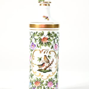 May include: White porcelain bottle with a gold rim and floral and bird design. The bottle features a detailed painting of two birds on a branch, surrounded by colorful flowers and green leaves. A butterfly and a pink flower adorn the top.