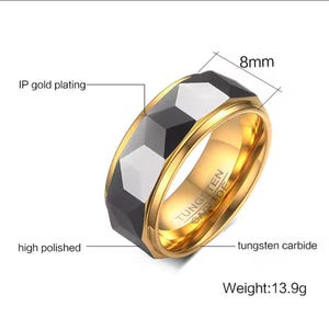 May include: A high-polished, gold-plated tungsten carbide ring with a black and silver geometric design. The ring is 8mm wide and weighs 13.9 grams.