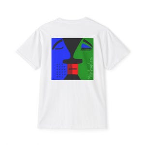 以下が含まれることがあります： カラフルな抽象的な顔のデザインが特徴の白いTシャツ。デザインには青、緑、赤、黒の形が含まれており、テキスト「Bonhini/1726」は緑色です。Tシャツは、クラシックなクルーネックです。