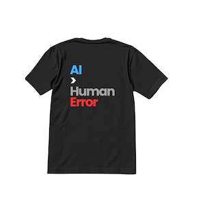 May include: Black t-shirt with the text "AI > Human Error" in blue, gray, and red. The shirt is a crew neck style and appears to be made of a soft material. The text is centered on the shirt.