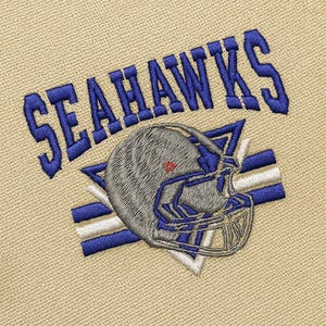 May include: Embroidered patch featuring the word "SEAHAWKS" in blue above a football helmet. The helmet is gray and blue with a red accent. The background is a tan fabric.