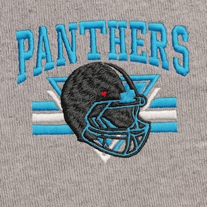 May include: Embroidered design on a gray fabric. The design features the word "PANTHERS" in turquoise block letters above a black football helmet with turquoise accents. A red dot is on the helmet.