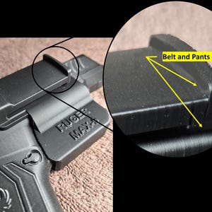 May include: Black polymer holster for a Ruger Max-9 pistol. The holster features a belt and pants grip design for secure carry. The Ruger Max-9 model name is visible on the side of the holster. The holster is designed for concealed carry.