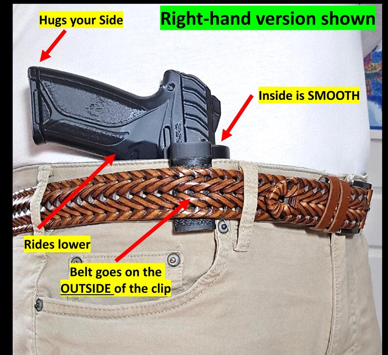 Op de afbeelding: Een zwart pistoolholster wordt getoond, vastgeklikt aan een bruine gevlochten leren riem. De tekst "Right-hand version shown" is zichtbaar. Het holster is ontworpen om lager te zitten en de zijkant te omarmen. De riem gaat aan de buitenkant van de clip.