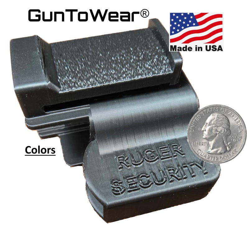 Op de afbeelding: Zwart Ruger Security accessoire met getextureerde oppervlakken. Het product heeft de tekst "Ruger Security" en "Made in USA". Een munt is inbegrepen ter groottevergelijking. Het product is van GunToWear.