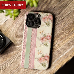 Puede incluir: Funda de teléfono floral con diseño vintage. La funda presenta un fondo color crema con rosas rosas y hojas verdes. Una franja vertical con fondo verde claro y detalles de encaje rosa se encuentra en el lado izquierdo.