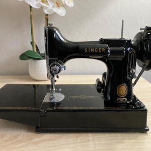 Singer Featherweight 221 Sewing Machine, 1952 USA Model. Fully functional w original case and pedal. Vintage black and gold collectible item