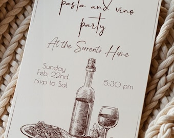 Può includere: Un biglietto d'invito color crema con il testo "pasta and vino party" e illustrazioni di una bottiglia di vino, un bicchiere e pasta. La carta include anche la data, l'ora e le informazioni RSVP. La carta è appoggiata su una coperta beige a maglia grossa.