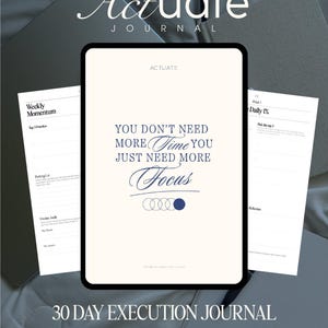 May include: The Actuate Journal is a 30-day execution journal featuring a white cover with the text, "YOU DON'T NEED MORE TIME YOU JUST NEED MORE FOCUS" in dark blue, accompanied by a series of circles. The journal is displayed with open pages.