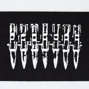 Può includere: Toppa bianca e nera con un disegno di sette coltelli in fila.