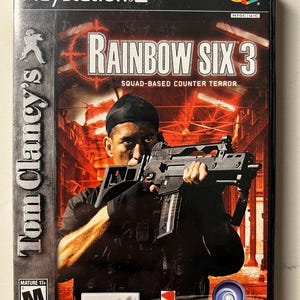 Puede incluir: Caja de videojuego de PlayStation 2 para "Tom Clancy's Rainbow Six 3: Squad-Based Counter Terror". La portada muestra a un hombre con un arma. El t&iacute;tulo del juego es prominente. La caja tiene una clasificaci&oacute;n ESRB Mature 17+.