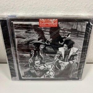May include: A CD case featuring a black and white image of two people in patterned outfits. The text "ICKY THUMP" is displayed in a red banner at the top of the case. The image is in a clear plastic case.